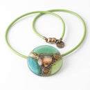 green round glass pendant on green leather cord
